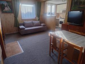 a living room with a couch and a table at Domek nad jeziorem -Mazury- Linia Brzegowa in Piotrowice