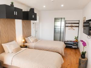 a bedroom with two beds and a television in it at Appartement 4 ou 2 Parking Wifi Terrasse cosy in Condé-sur-Sarthe
