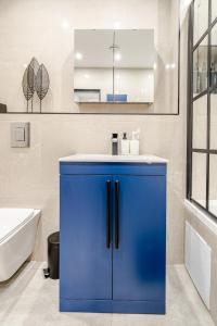 a blue cabinet in a bathroom with a sink at Luxury Apartment Close to Elstree & Borehamwood Station in Borehamwood +14 photos
