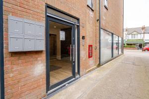 a brick building with sliding glass doors on it at Luxury Apartment Close to Elstree & Borehamwood Station in Borehamwood