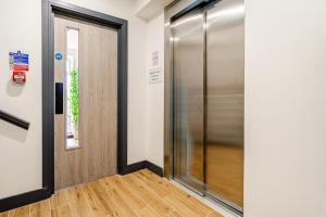 a hallway with a door and a window at Luxury Apartment Close to Elstree & Borehamwood Station in Borehamwood