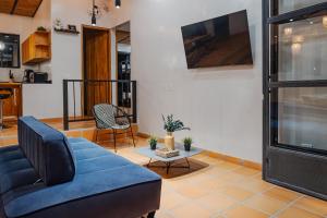a living room with a blue couch and a tv at Casa Campestre, la Mesa, Vía San Joaquín in La Mesa