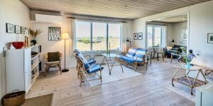 a living room with chairs and a table and a living room at VE072-Vejers-Strand-Violvej-9 in Vejers Strand
