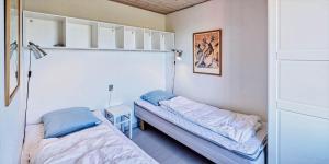 a small room with two beds and a table at VE072-Vejers-Strand-Violvej-9 in Vejers Strand