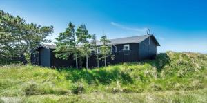 a black house sitting on top of a hill at VE072-Vejers-Strand-Violvej-9 in Vejers Strand