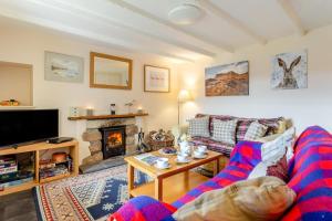 a living room with a couch and a fireplace at 2 Bed in Lairg oc-75909 in Badcall