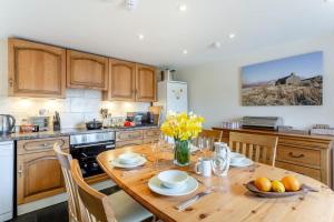 a kitchen with a wooden table with yellow flowers on it at 2 Bed in Lairg oc-75909 in Badcall +11 photos