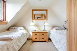 two beds in a attic bedroom with a mirror at 2 Bed in Lairg oc-75909 in Badcall