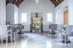 a room with tables and chairs and a stove at Pierneef's Kraal in Pretoria