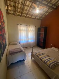 a bedroom with two twin beds and a window at Quintal da prainha Bar - pousada simples-beira da lagoa in Santana do Riacho