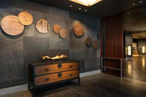 a room with a dresser and wooden plates on the wall at DoubleTree by Hilton Kyoto Station in Kyoto