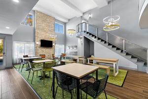 a cafeteria with tables and chairs and a staircase at Spark By Hilton Redlands in Redlands