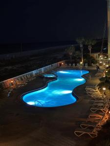 a swimming pool at night with blue lights at 3BR Beachfront Huge Balcony 2 Pools Luxury in Fort Walton Beach