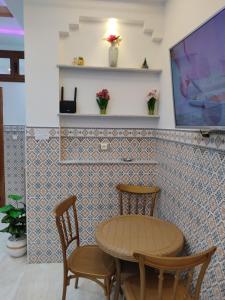 a table and two chairs and a tv on a wall at اقامة يوسف اللكراء in Gabès
