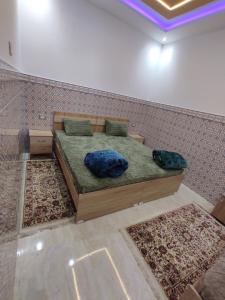 a bed in a room with two rugs at اقامة يوسف اللكراء in Gabès