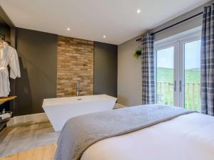 a bedroom with a large bed and a bath tub at 1 Bed in Colne oc-86513 in Rawdon