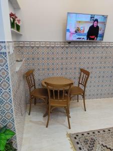 a table and chairs in a room with a wall at اقامة يوسف اللكراء in Gabès