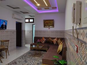 a living room with a couch and a tv at اقامة يوسف اللكراء in Gabès