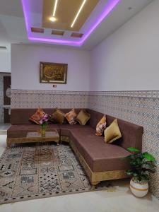 a living room with a brown couch and a table at اقامة يوسف اللكراء in Gabès +1 photo
