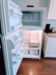 an empty refrigerator with its door open in a kitchen at Executive Suite 2 Bedroom Serviced Apartment in Alert Bay