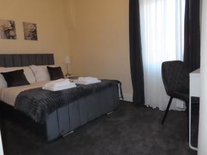 a bedroom with a bed with a chair and a window at Portman House in Middlesbrough