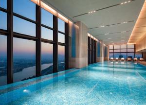 a large swimming pool in a building with windows at DoubleTree by Hilton Zhangzhou in Zhangzhou