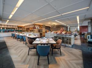 a restaurant with tables and chairs and a kitchen at DoubleTree by Hilton Zhangzhou in Zhangzhou