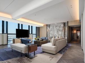 a living room with a couch and a tv at DoubleTree by Hilton Zhangzhou in Zhangzhou