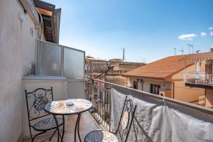 a balcony with a table and chairs on a balcony at Hedoné apartment in Schisò