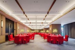 a long room with red tables and chairs at DoubleTree by Hilton Zhangzhou in Zhangzhou +77 photos