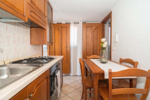 a kitchen with a table and a sink and a stove at Hedoné apartment in Schisò