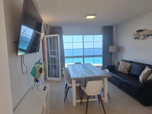 a living room with a table and a blue couch at Paraíso Jandia beach in Costa Calma