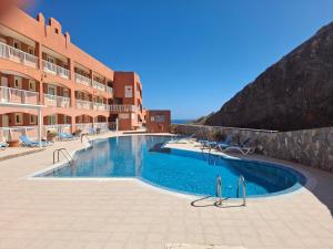 a swimming pool in front of a hotel at Paraíso Jandia beach in Costa Calma