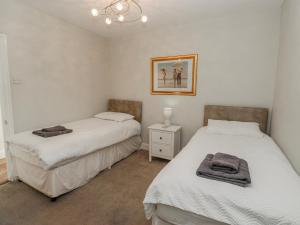 a bedroom with two beds and a picture on the wall at 49 Waddington Road in Clitheroe