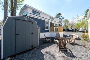 a small blue house with chairs and a table at Near Beach • Pool + Amenities • Sleeps 8 in Swain