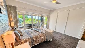 a bedroom with a bed and a large window at Galley Cove House in Geographe