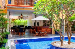 a restaurant with a table and chairs next to a pool at House Boutique Eco Hotel in Phnom Penh