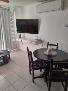 a dining room with a table and chairs and a tv at Mision del Sol 302 in Bahía Kino