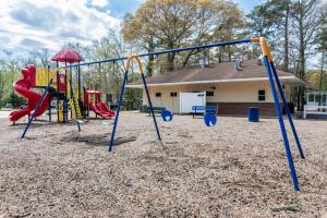 a playground with a swing set in front of a house at Pool • Fire Pit • Amenities • Sleeps 8 in Swain