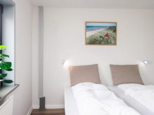 a bedroom with a white bed with a picture on the wall at Apartment in Holiday park- free waterpark in Ulfborg +53 photos
