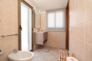 a bathroom with a sink and a toilet at Hedoné apartment in Schisò