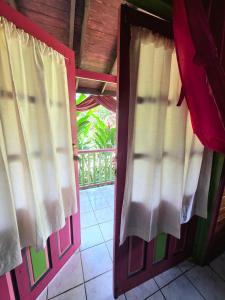 an open door with curtains in a room at 3 Rivers Eco Lodge in Rosalie