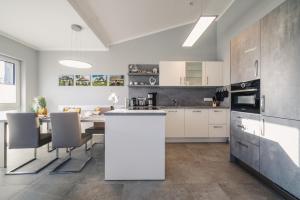 a kitchen with white cabinets and a table with chairs at Ferienwohnung Boddentraum in Zingst