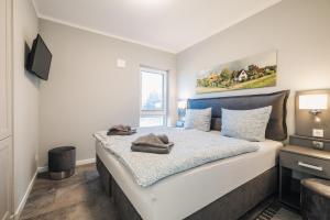 a bedroom with a bed with white sheets and a window at Ferienwohnung Boddentraum in Zingst