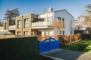 a blue gate in front of a house at Ferienwohnung Boddentraum in Zingst