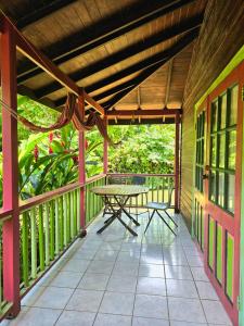 a patio with a table and chairs on a porch at 3 Rivers Eco Lodge in Rosalie