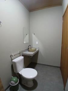 a bathroom with a white toilet and a sink at Slan Ville Hotel in Chapadão do Sul