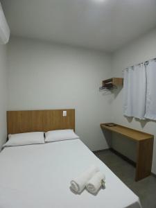 a bedroom with a bed with two towels on it at Slan Ville Hotel in Chapadão do Sul