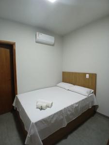 a bedroom with a bed with two towels on it at Slan Ville Hotel in Chapadão do Sul