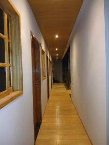 an empty hallway with a wooden floor and a window at Slan Ville Hotel in Chapadão do Sul